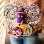 Woman in sweater holding butterfly diaper cake