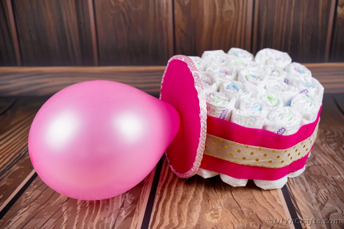 Balloon and diaper oversized pacifier on wooden table