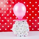 Pacifier diaper cake standing up in front of red polka dot wall
