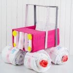 Pink box car made of diapers and covered box on white counter