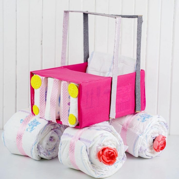 Voiture-boîte rose faite de couches et boîte couverte sur comptoir blanc