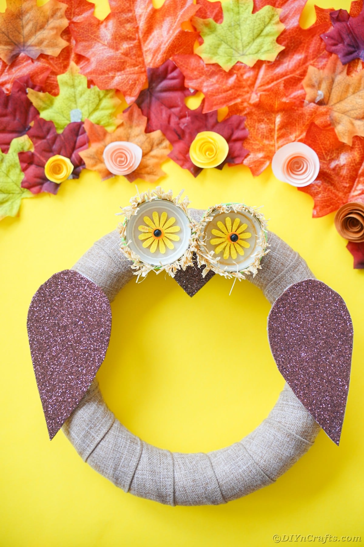 Yellow background behind owl wreath
