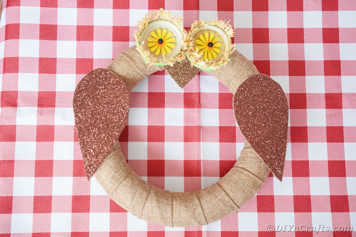 Rustic wreath looking like an owl on red and white table