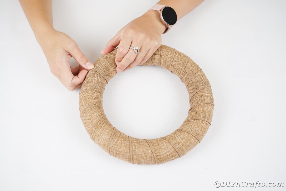 Hand wrapping wreath in burlap