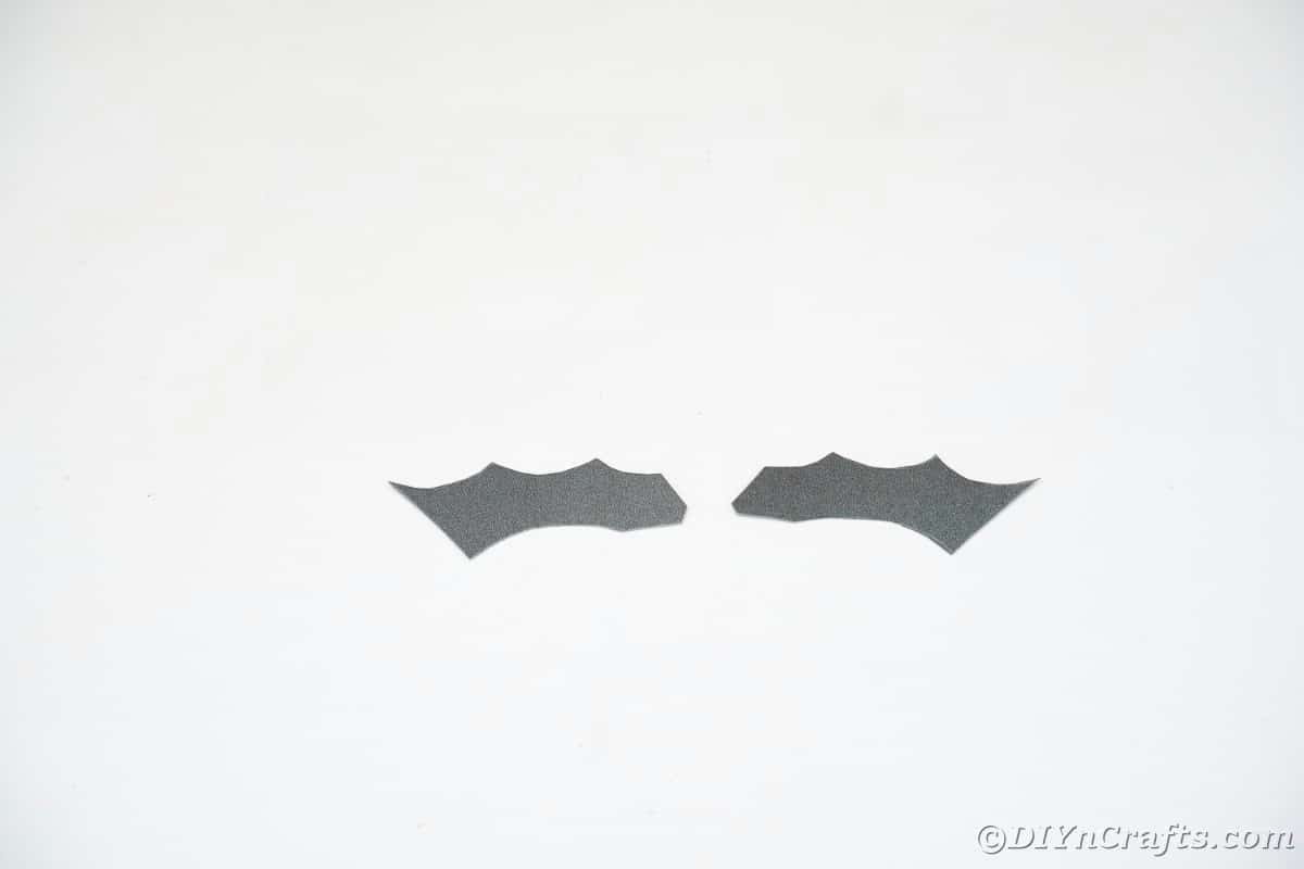 Black bat wing paper shape on white table