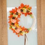 Floral and fall leaf wreath on glass door with wood trim