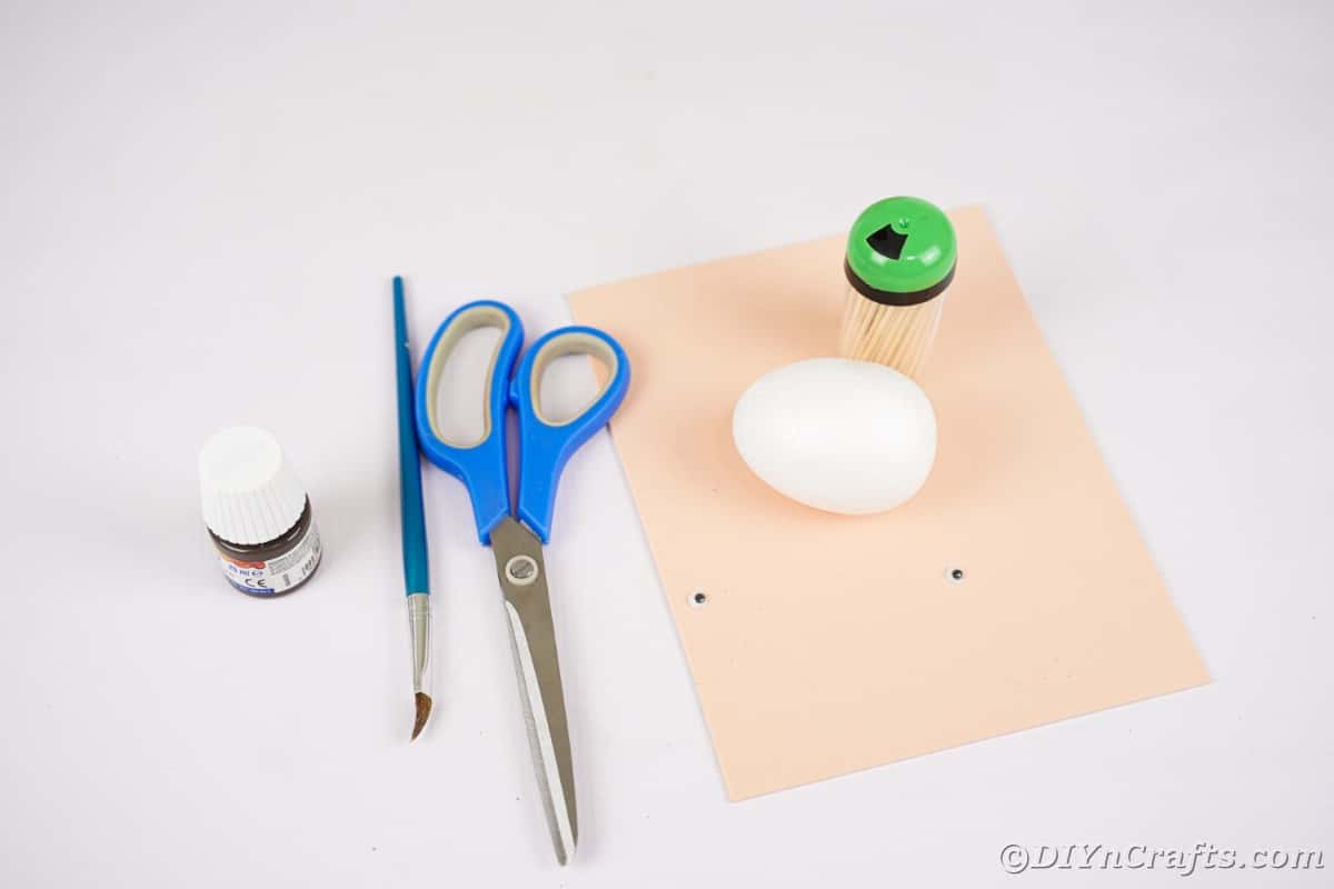 Tan foam paper and styrofoam egg with paint on white table