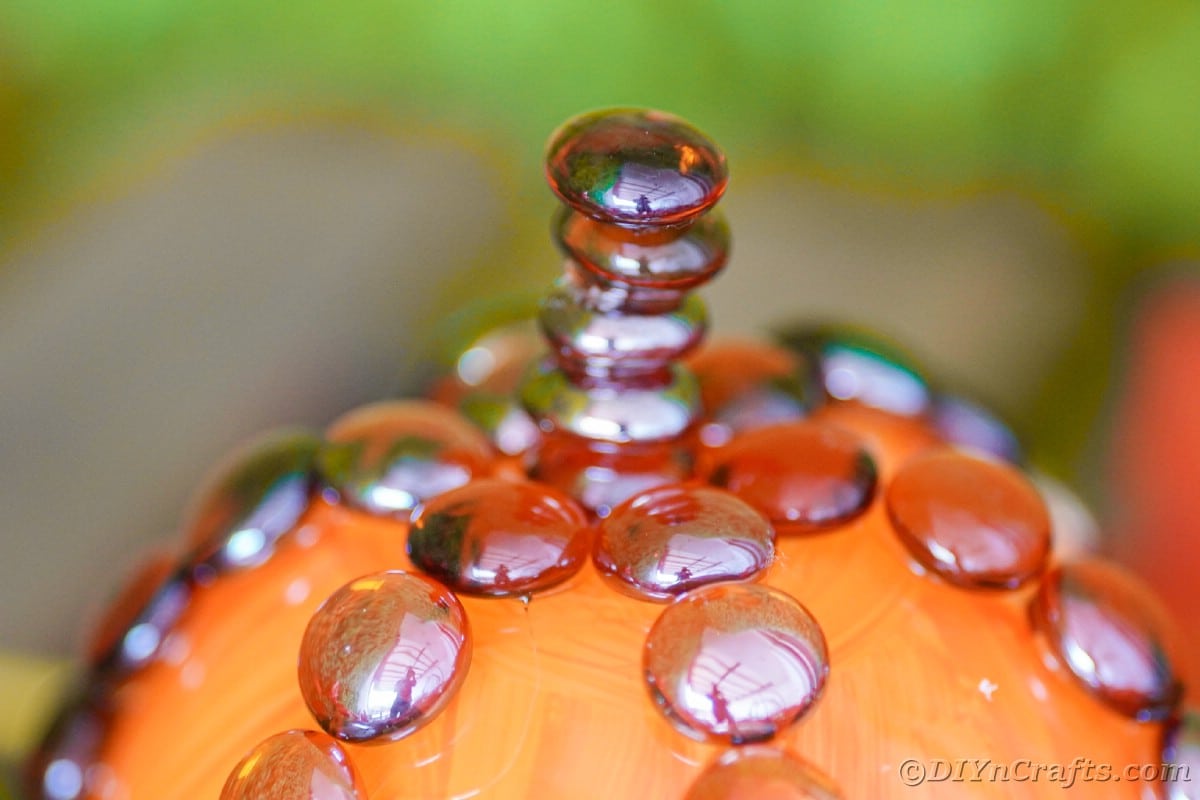 Brown rocks stacked on top of glass pumpkin as stem