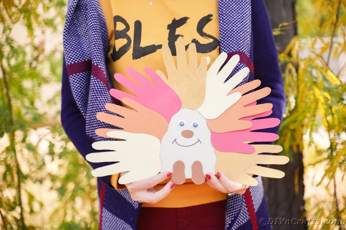 Handprint hedgehog being held by woman