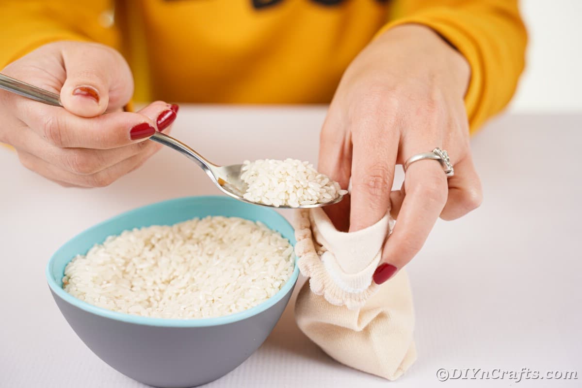 Hand filling sock with rice