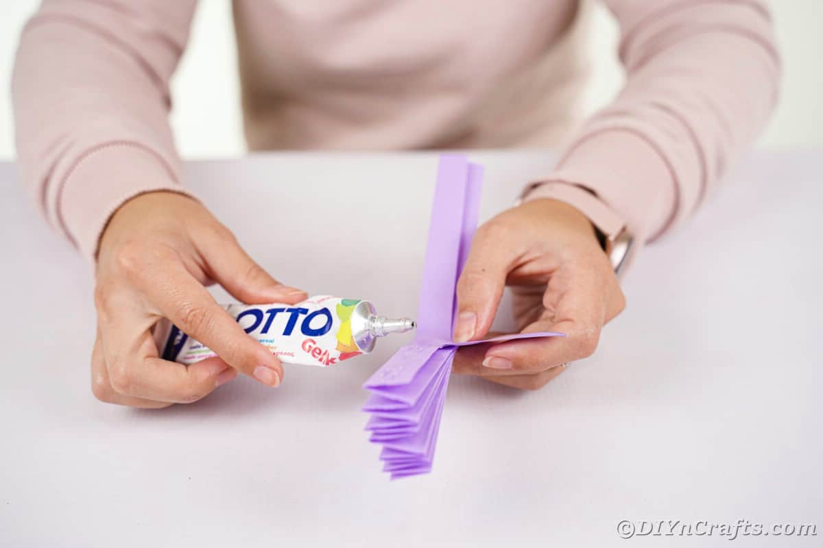 Woman putting glue on piece of paper
