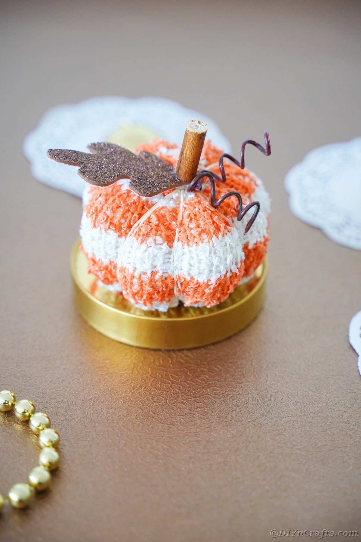 Stuffed sock pumpkin on gold surface