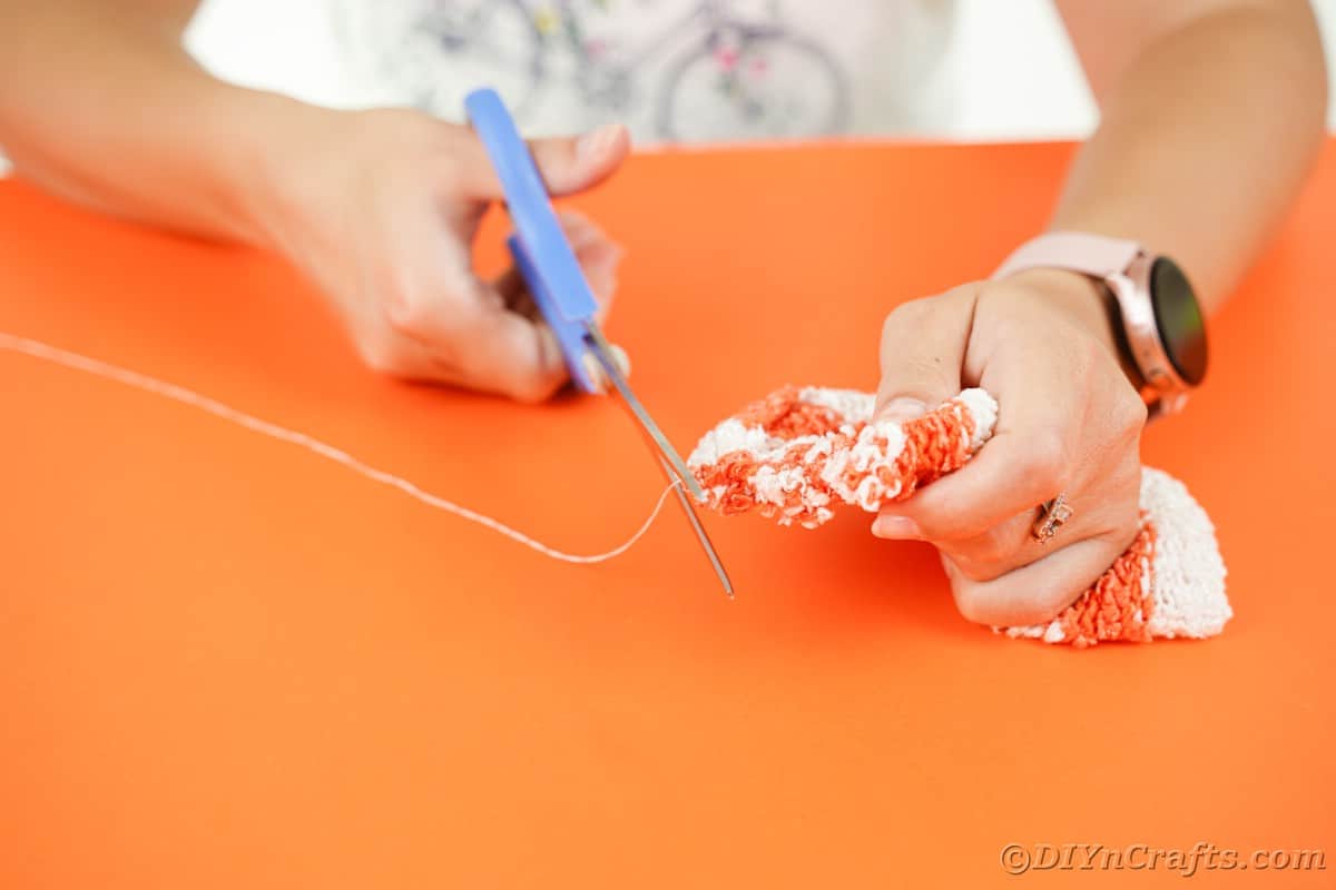 Hand cutting thread with blue scissors