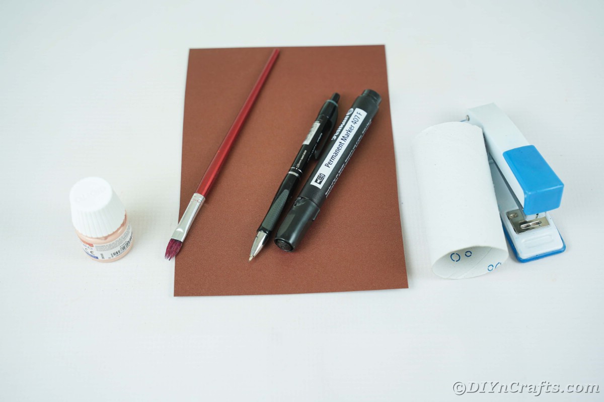 Braunes Papier mit Marker und Farbe auf weißem Tisch