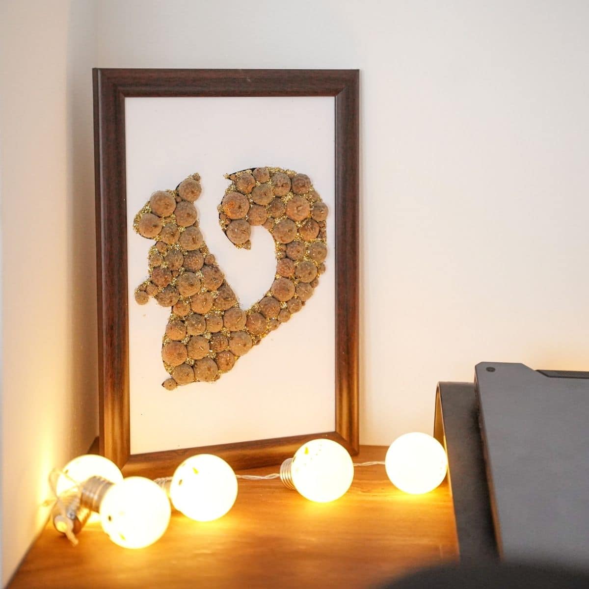 Squirrel wall art behind white lights against wall