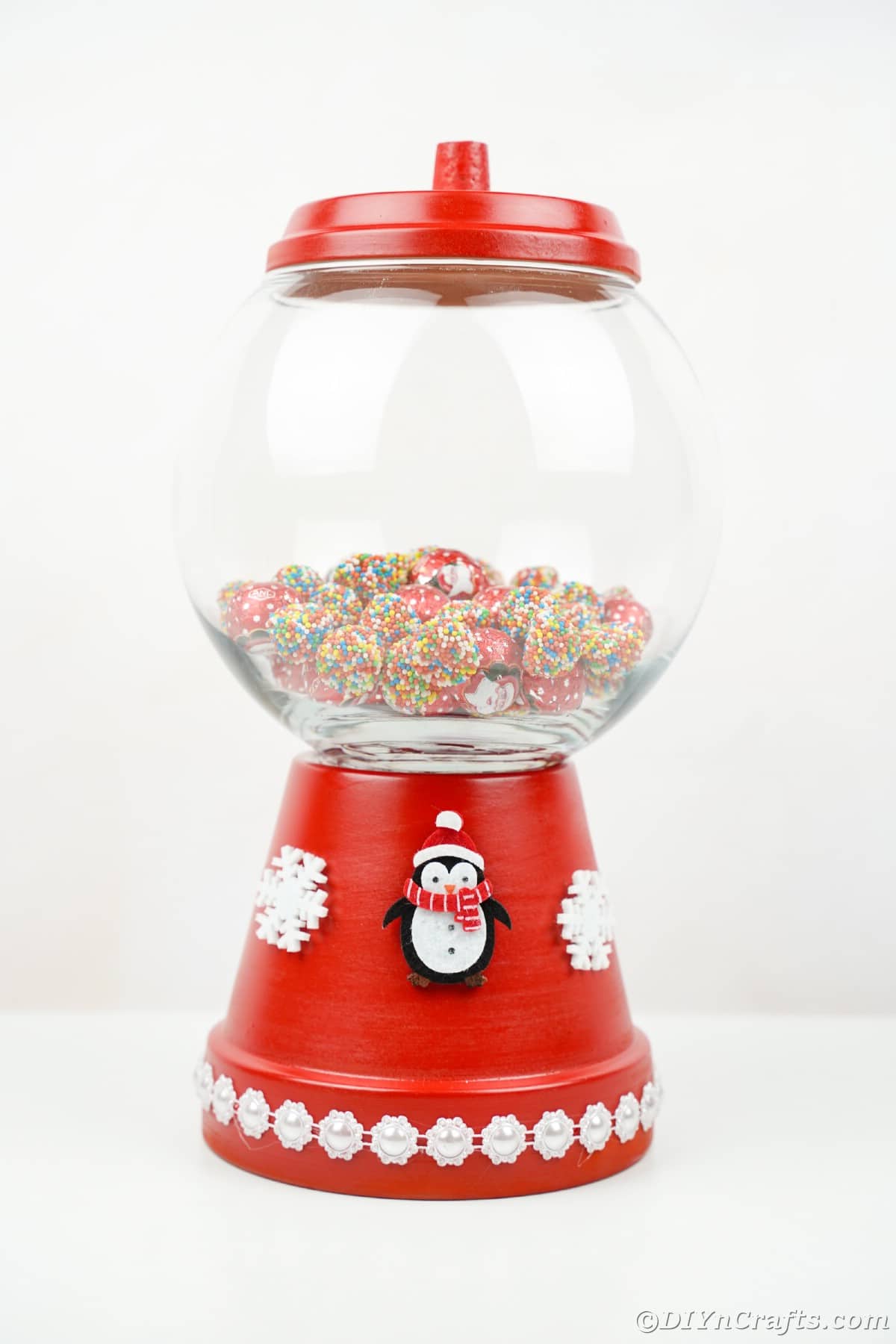 flower pot candy jar with penguin on base on white table