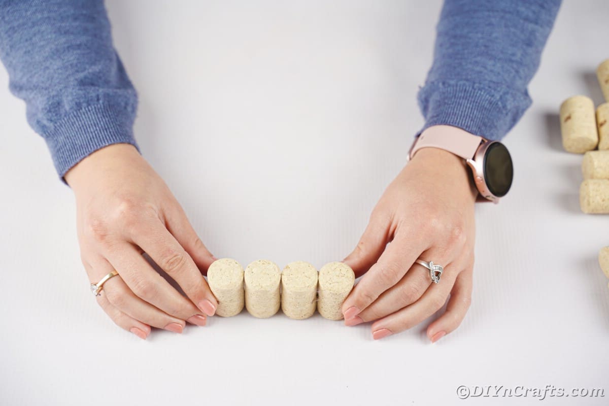 hands holding four cork together on table