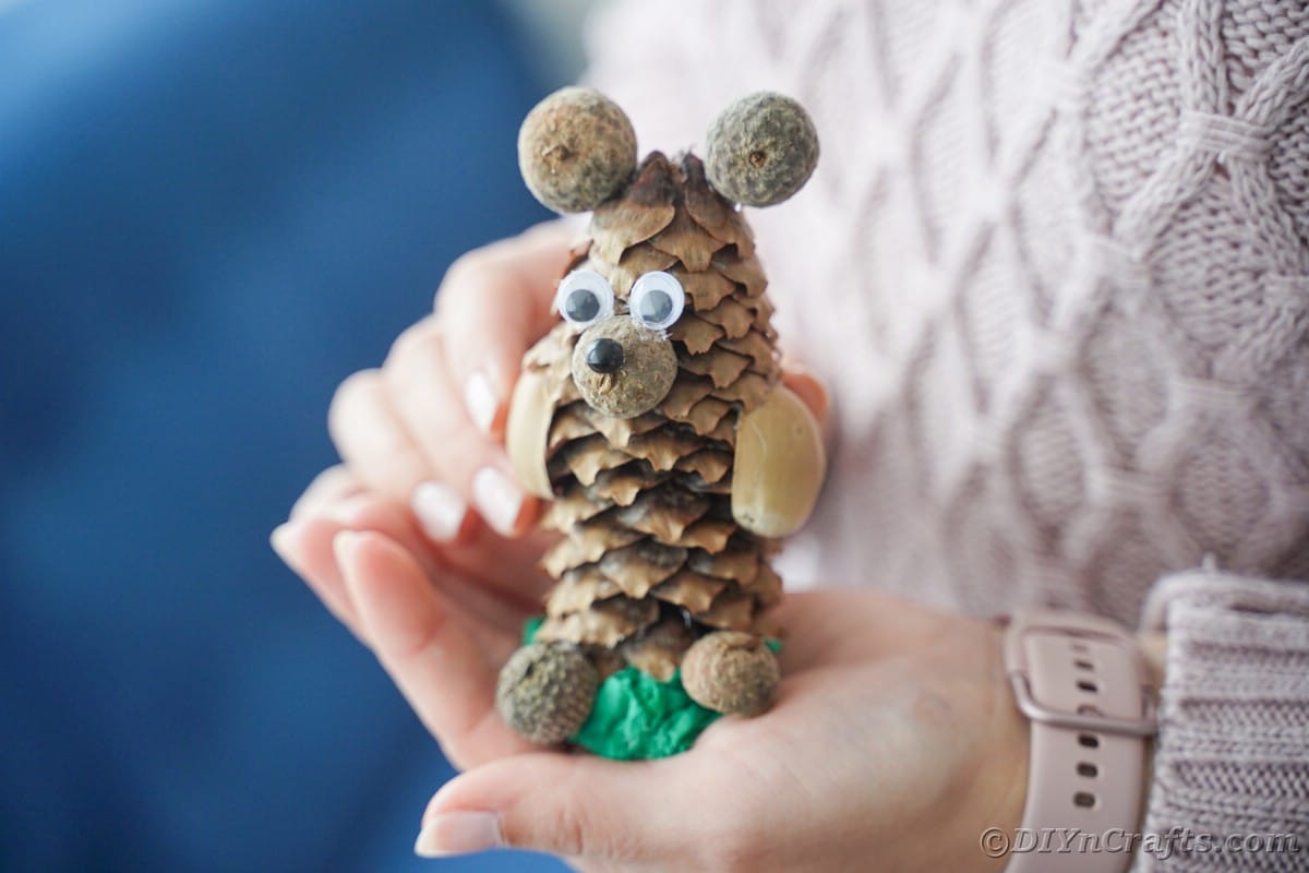 woman holding animal made from pine cone