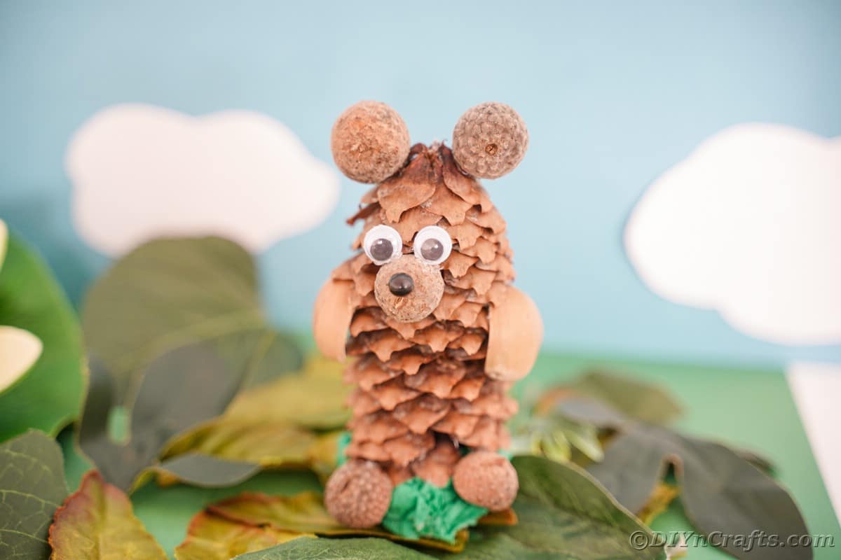 bear made of pine cone and nuts on top of fake leaves