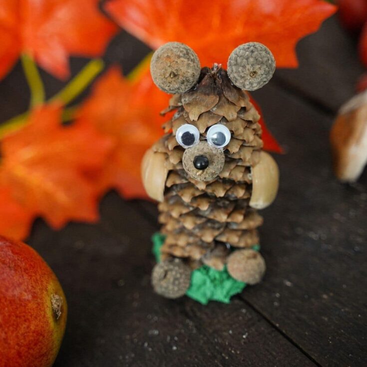 pinecone bear on wood table by fake leaves