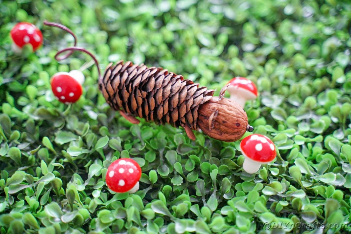 ponarejena miška na travi z mini rdečimi krastačami