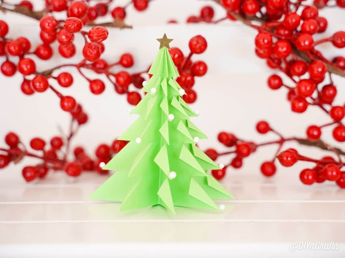 green paper tree by holly berries