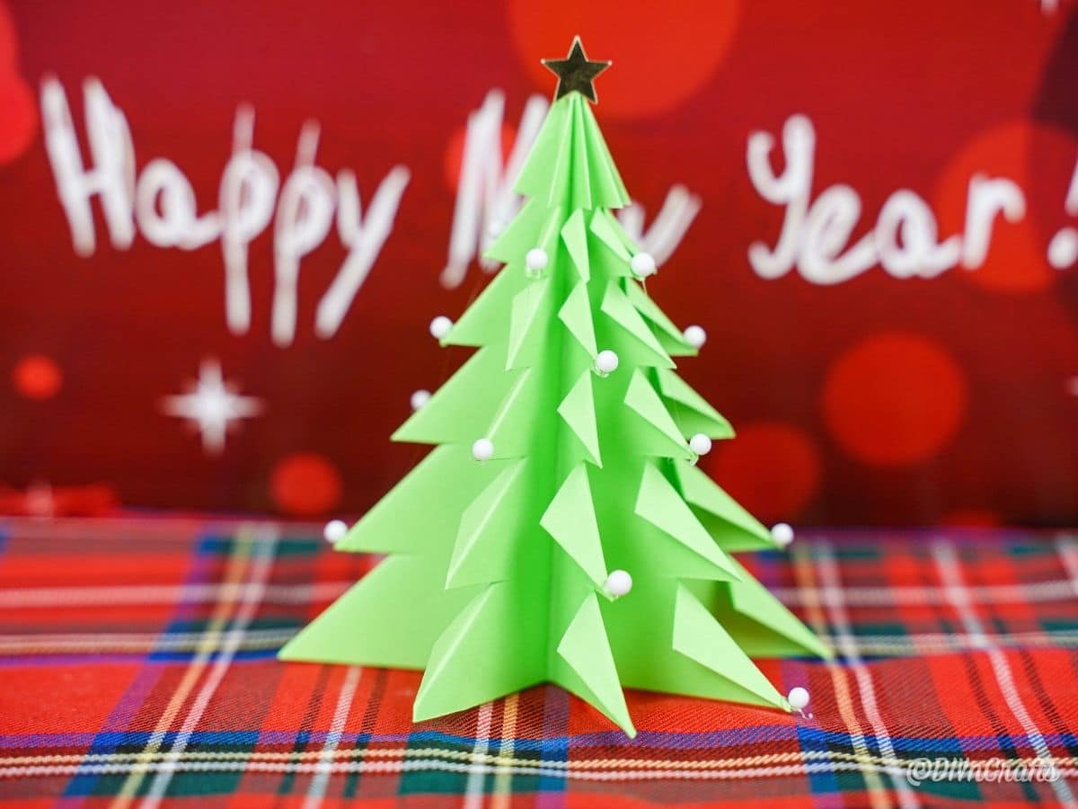 3D christmas tree on plaid in front of red sign