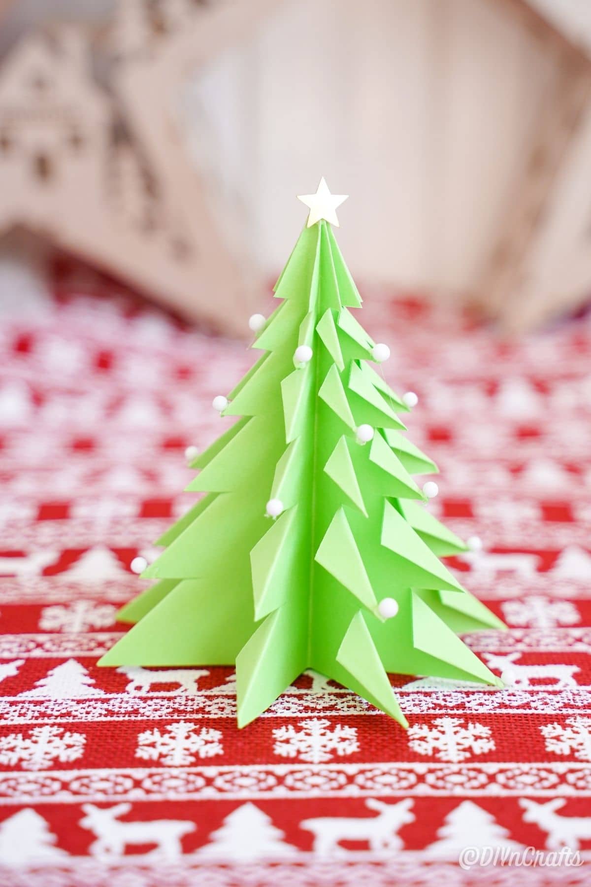 green paper tree on red and white holiday paper