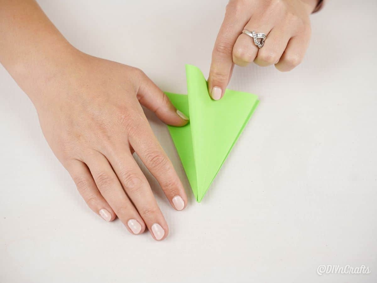 hands folding on green paper