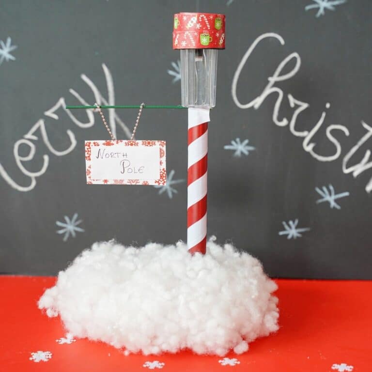 north pole street sign on red table with chalkboard in background