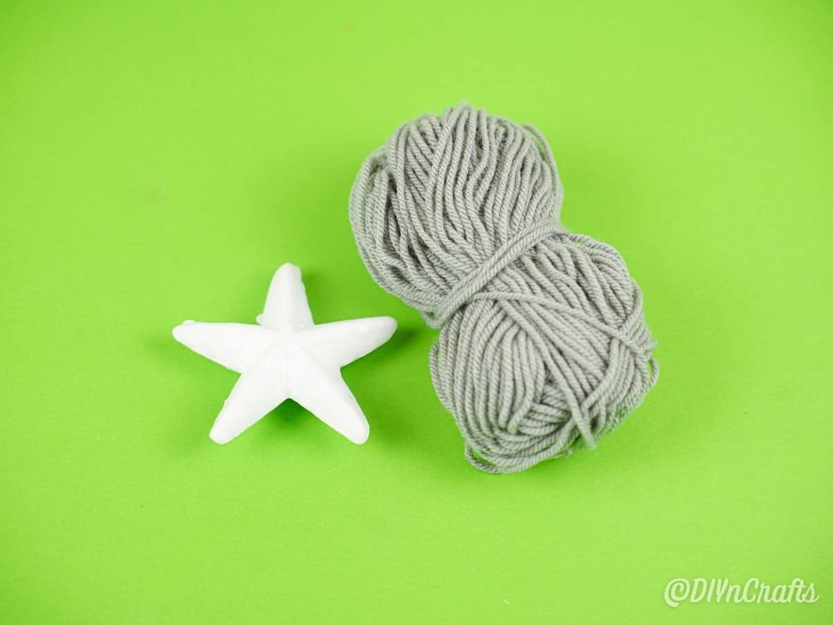 gray yarn and white star on green table