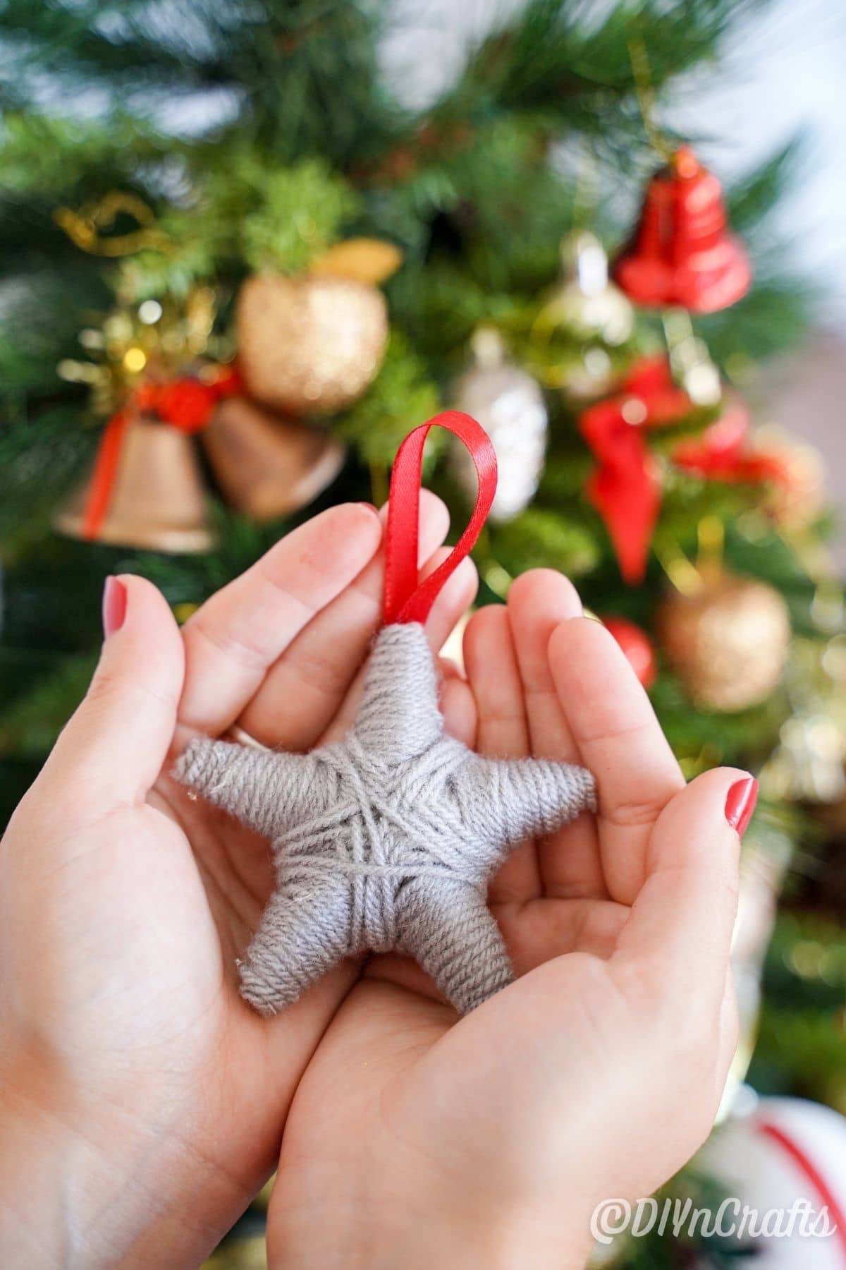 womans hands holding yarn ornament