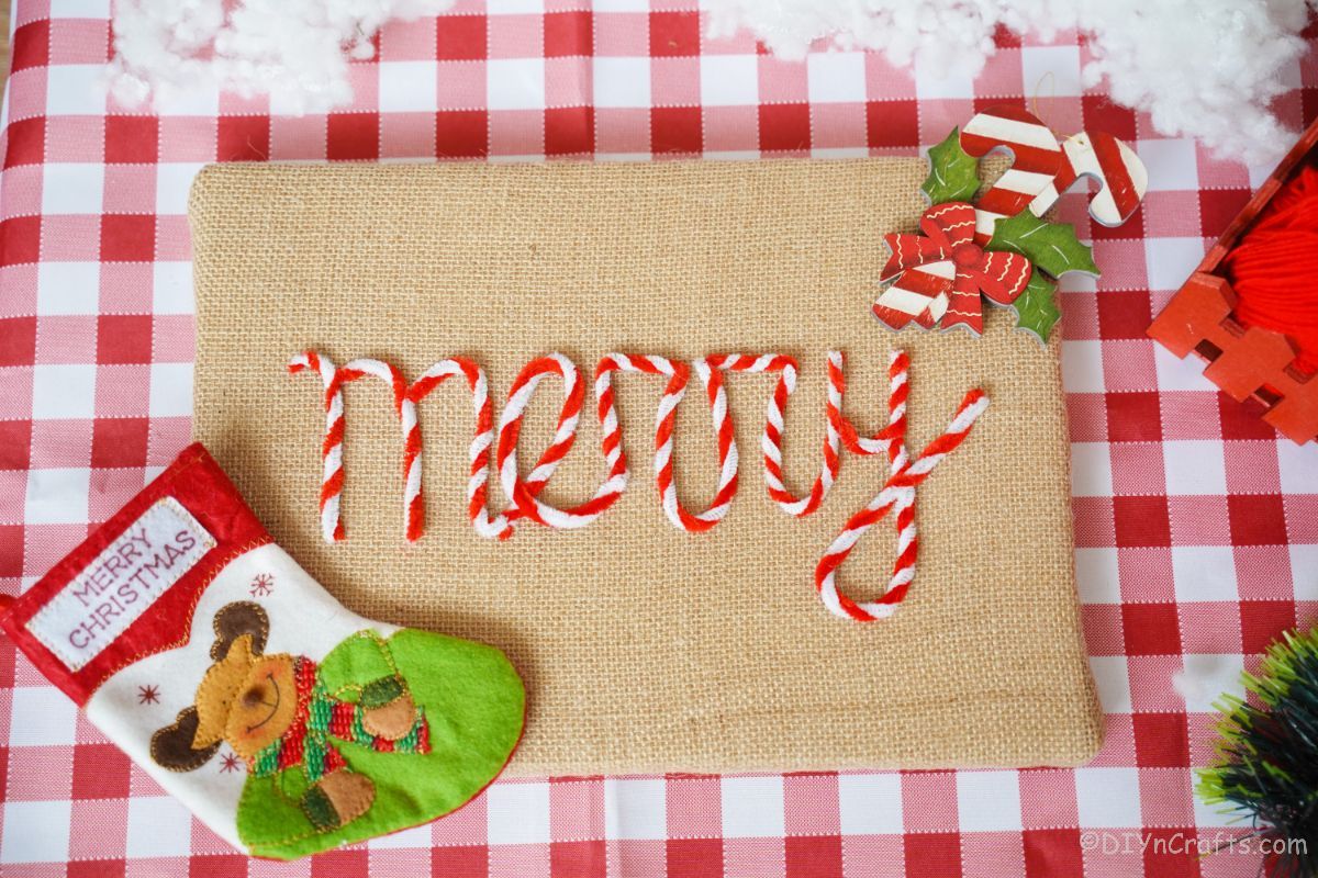 holiday themed burlap sign on red and white checked table