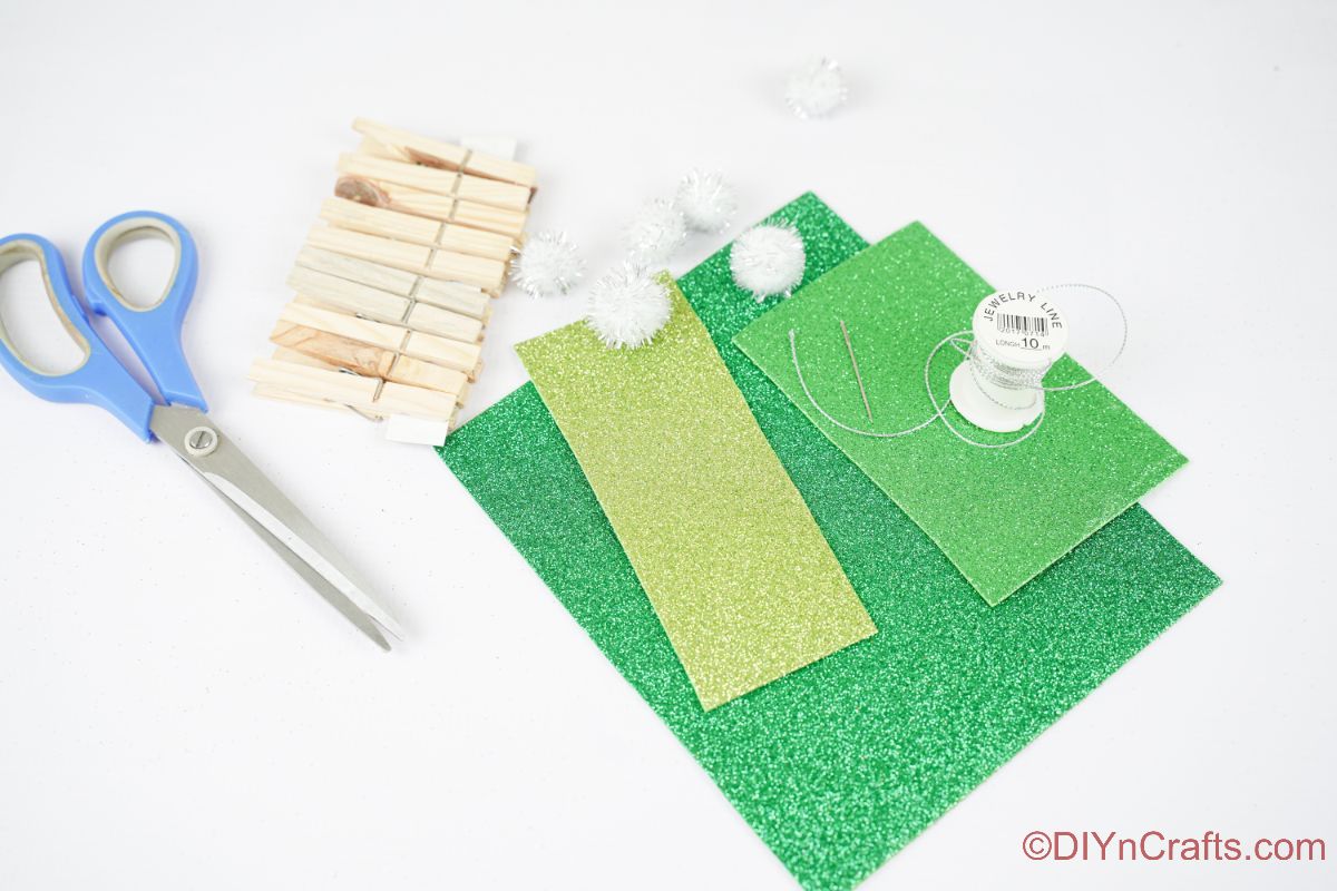 bela miza z zelenimi papirnatimi sponkami za perilo in pom pom