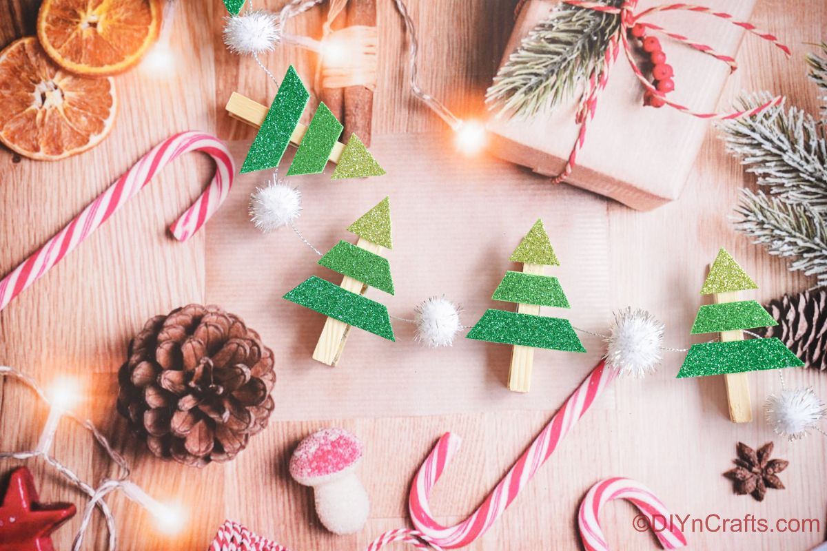 Mini guirlande de sapin de Noël portant par des cannes de bonbon sur du papier de vacances