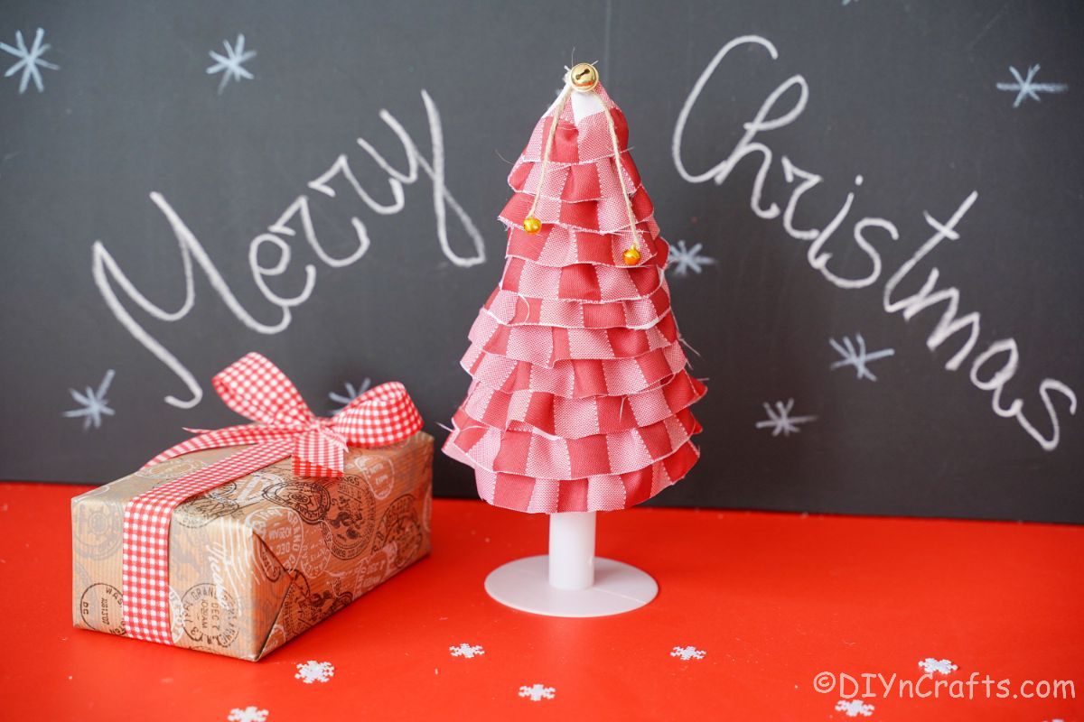 red plaid mini tree in front of chalkboard merry christmas sign