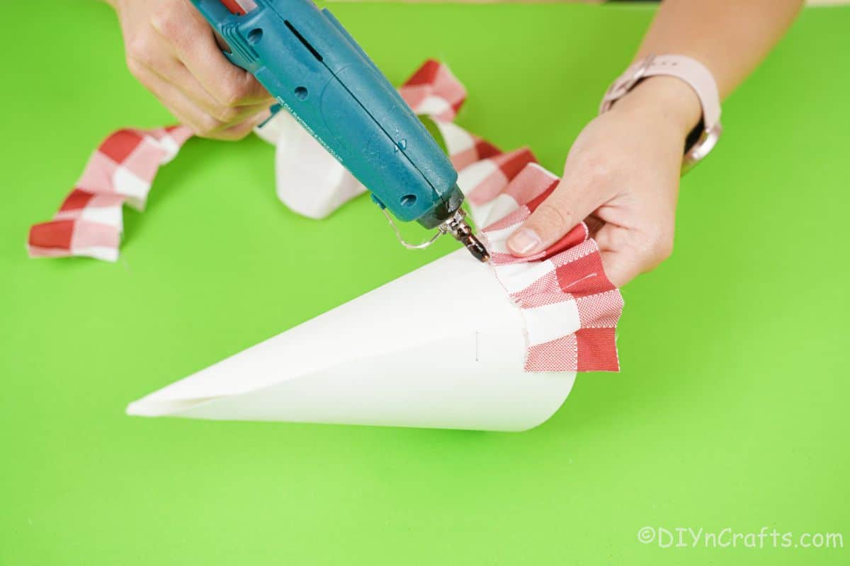hand gluing ribbon to paper cone