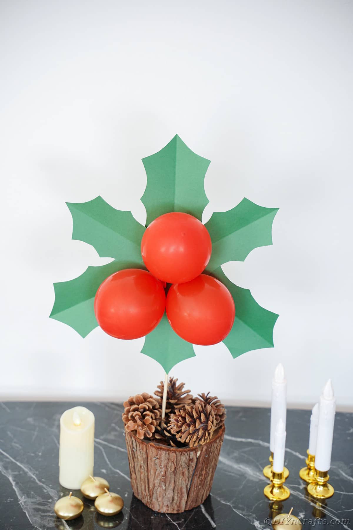 giant holly and berry decoration in bucket with pinecones
