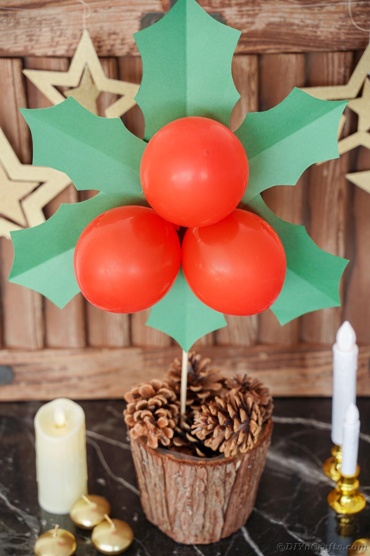 dekoracija listov božikovine in jagodičja v vedru s storži