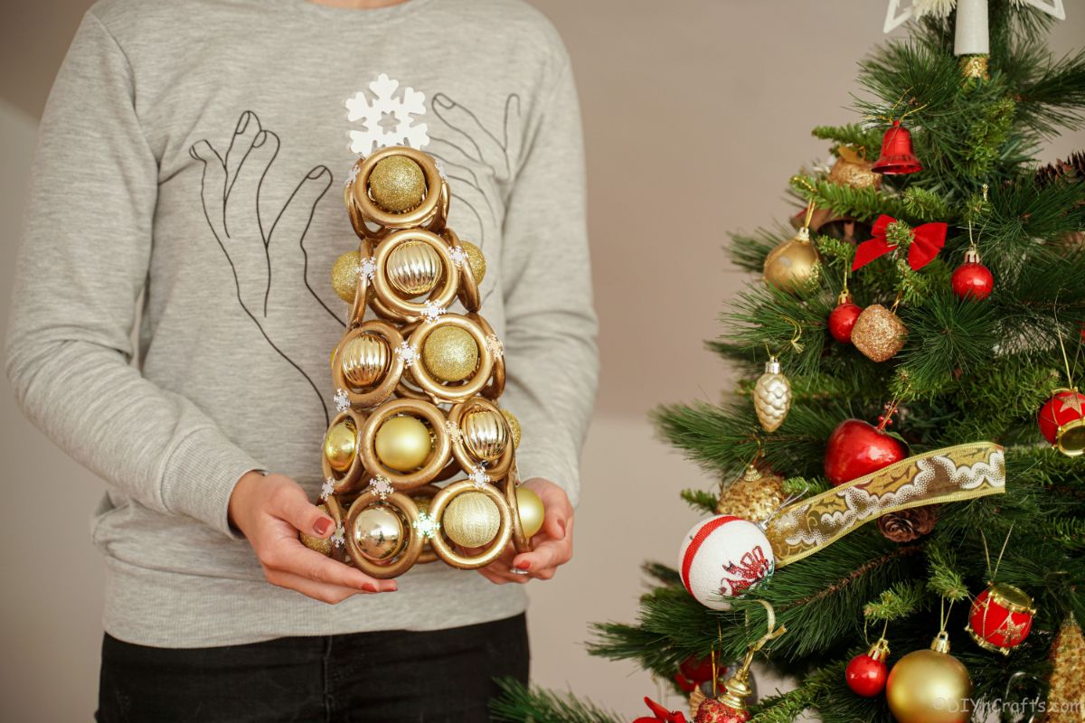 zlato božično drevo, ki poteka pred pravim božičnim drevesom