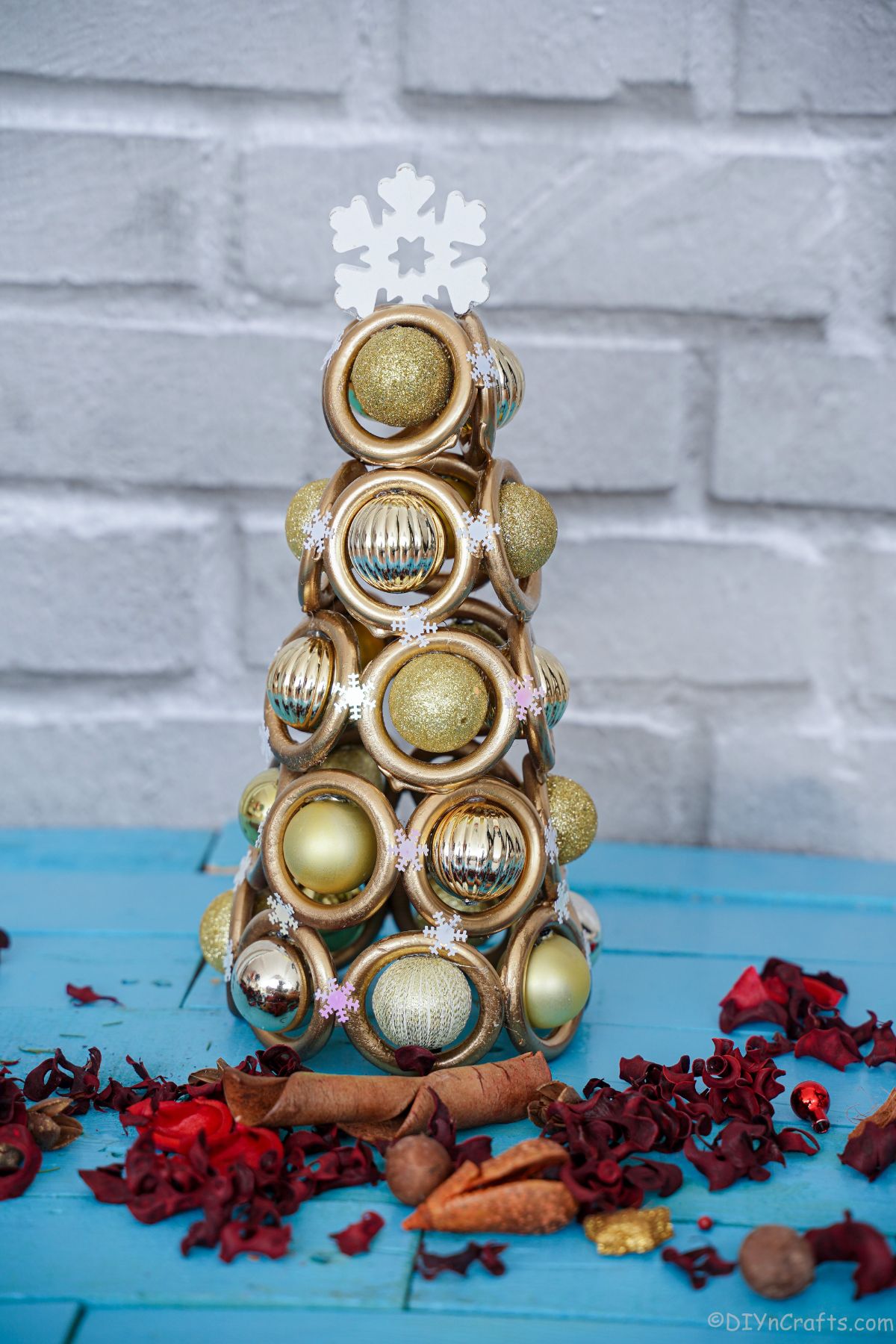 blue table with gold Christmas tree in front of gray brick