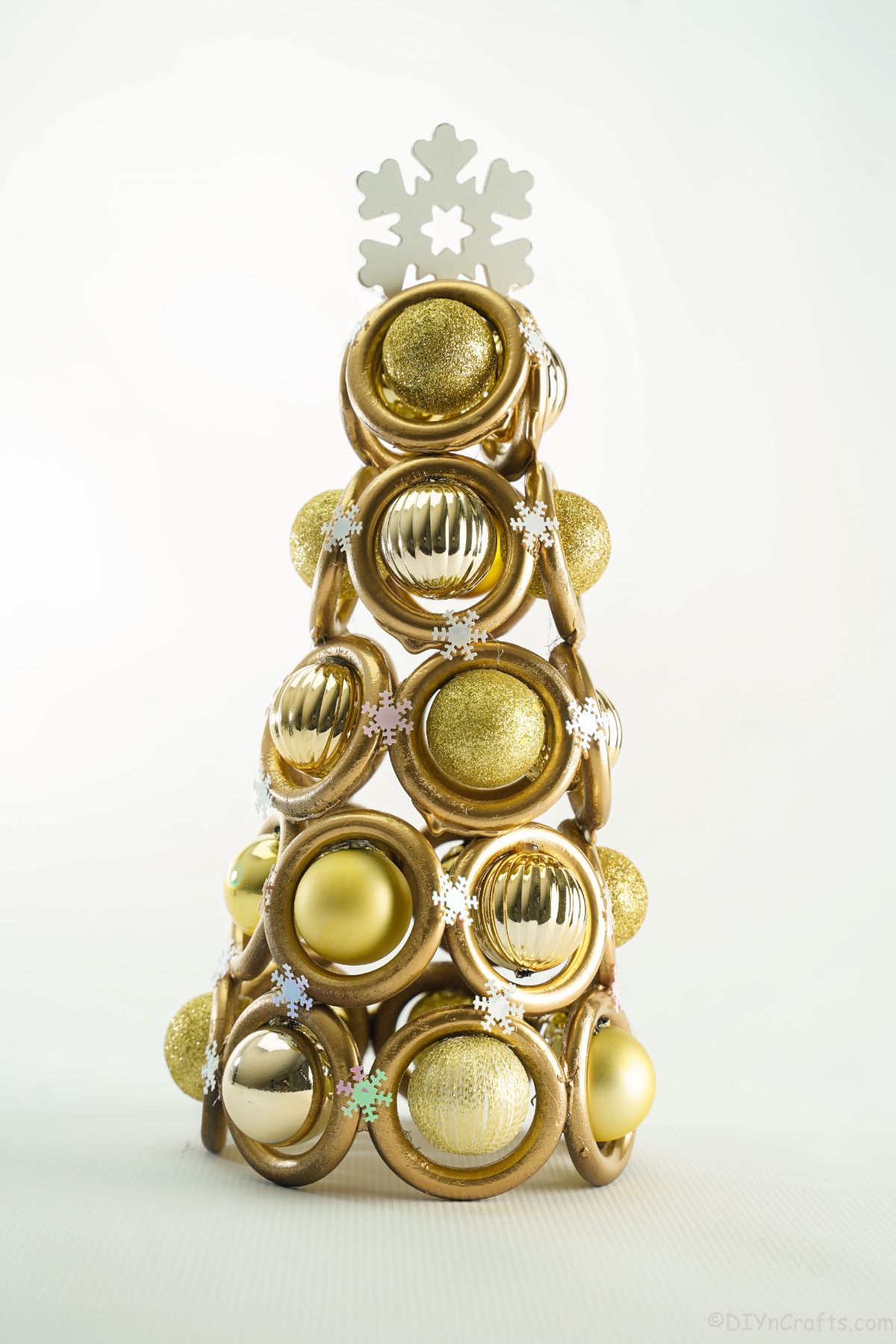 miniature gold ring tree on white table