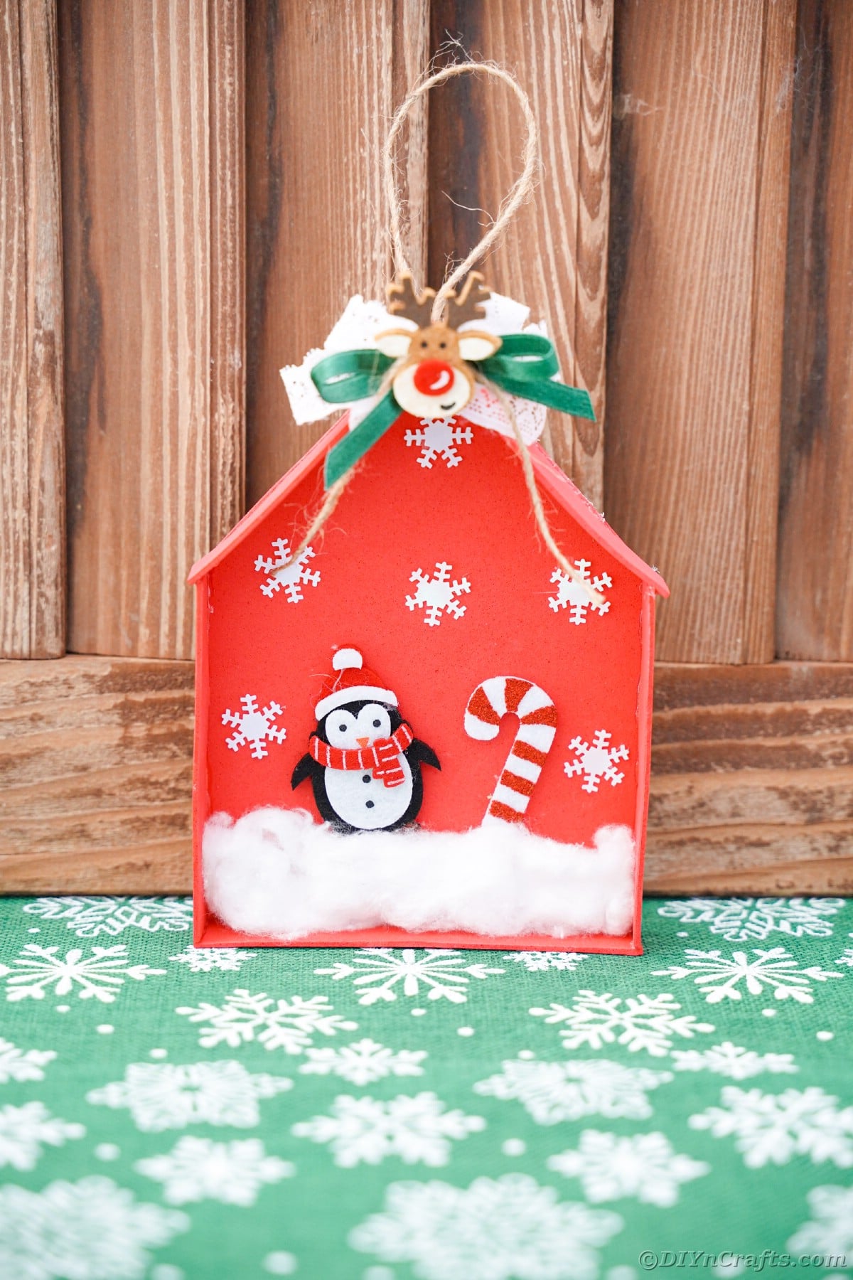 wood background behind red foam house ornament