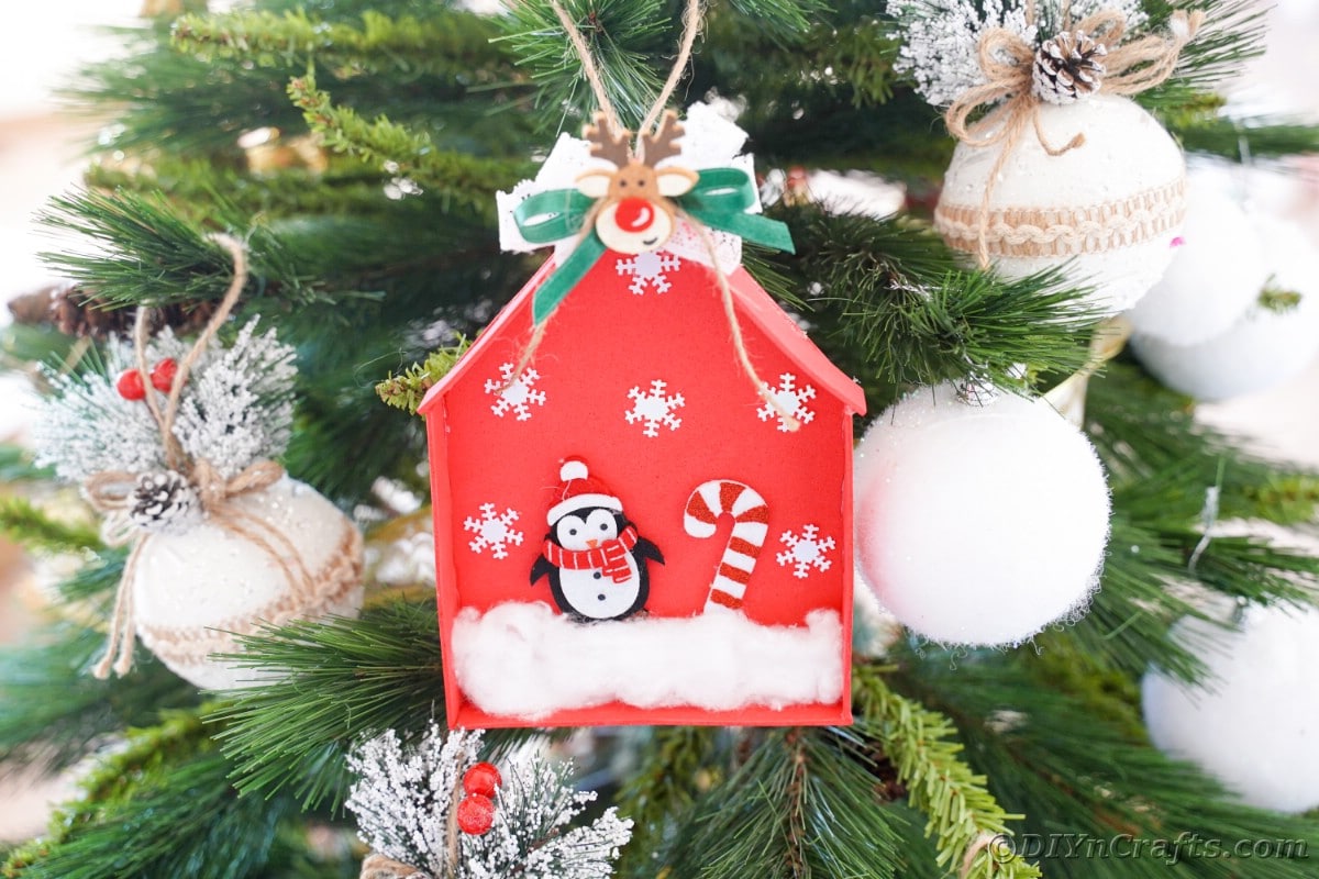 red foam penguin house ornament hanging on christmas tree