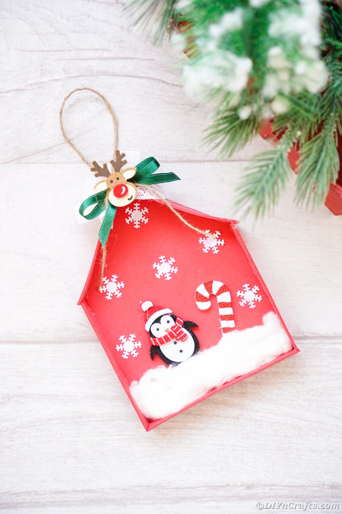 mini red house ornament laying on white board