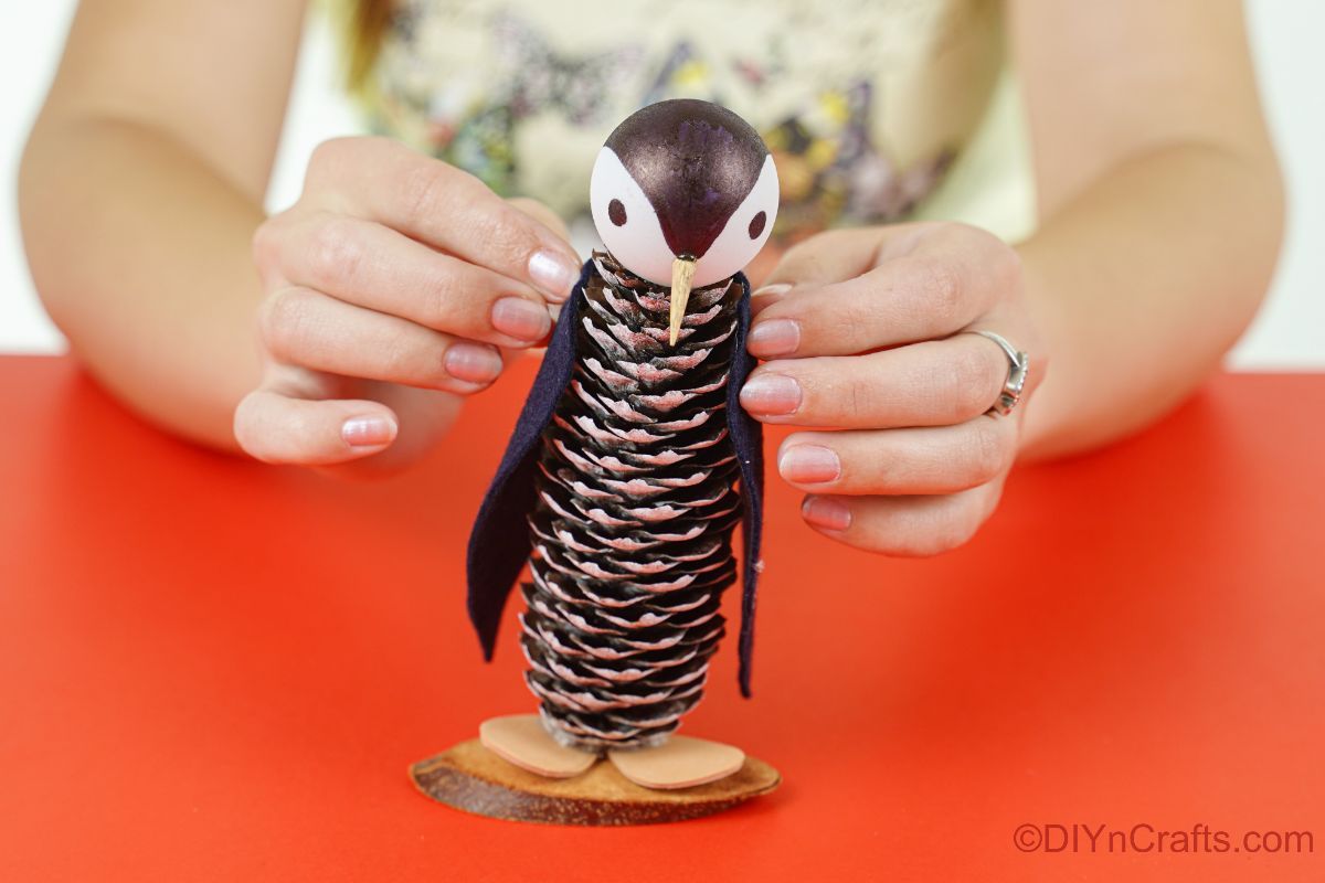 lady gluing felt wings on penguin craft