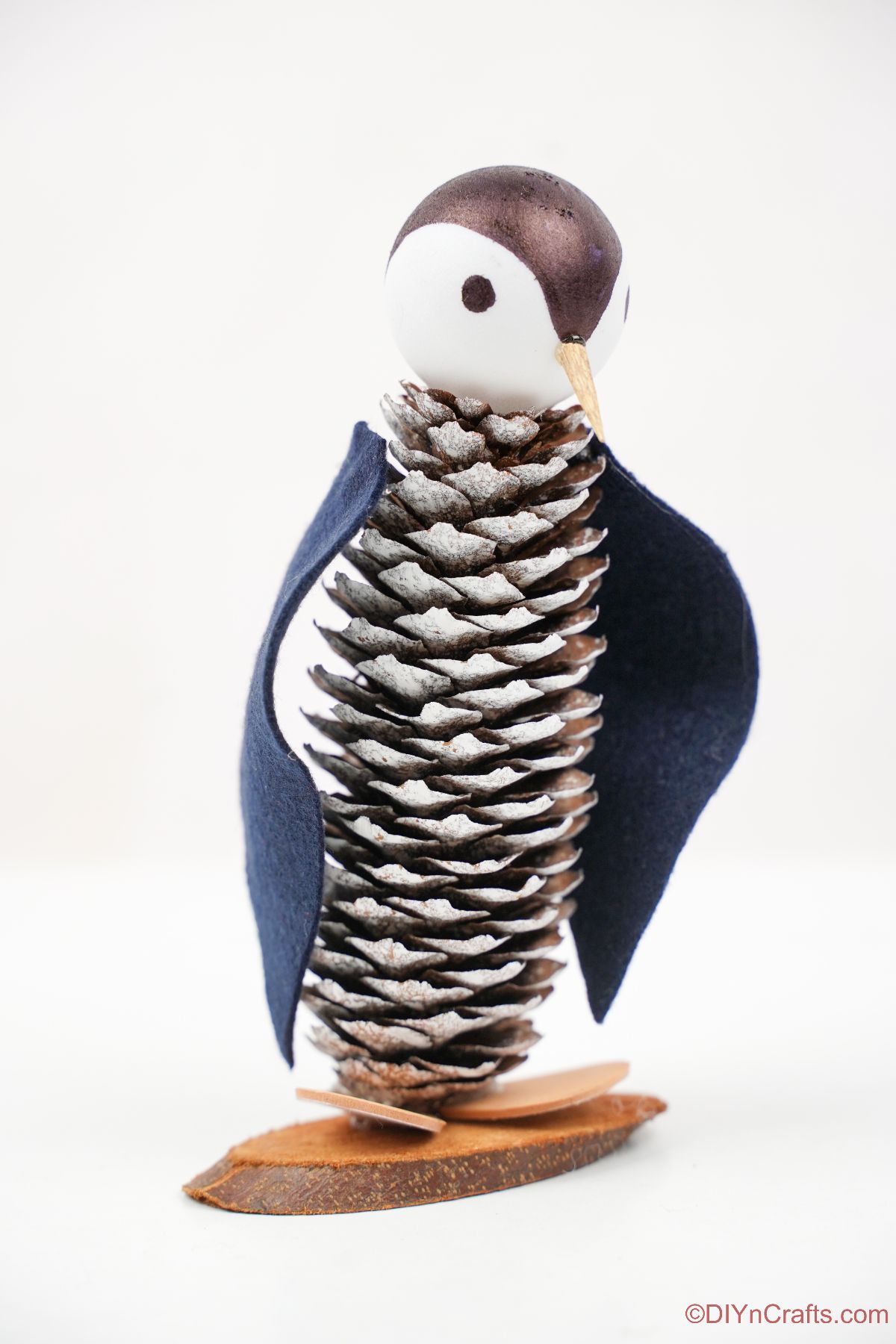 pinecone penguin sitting on white background
