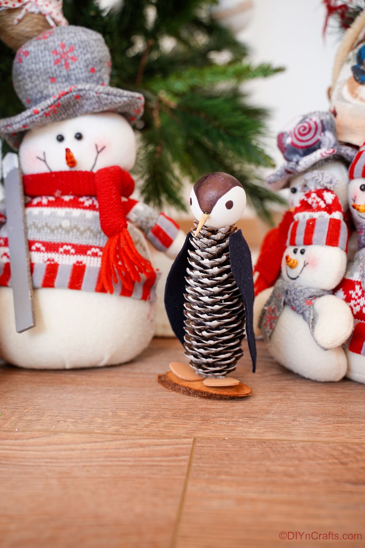 pinecone penguin on wood table with fake snowman in background