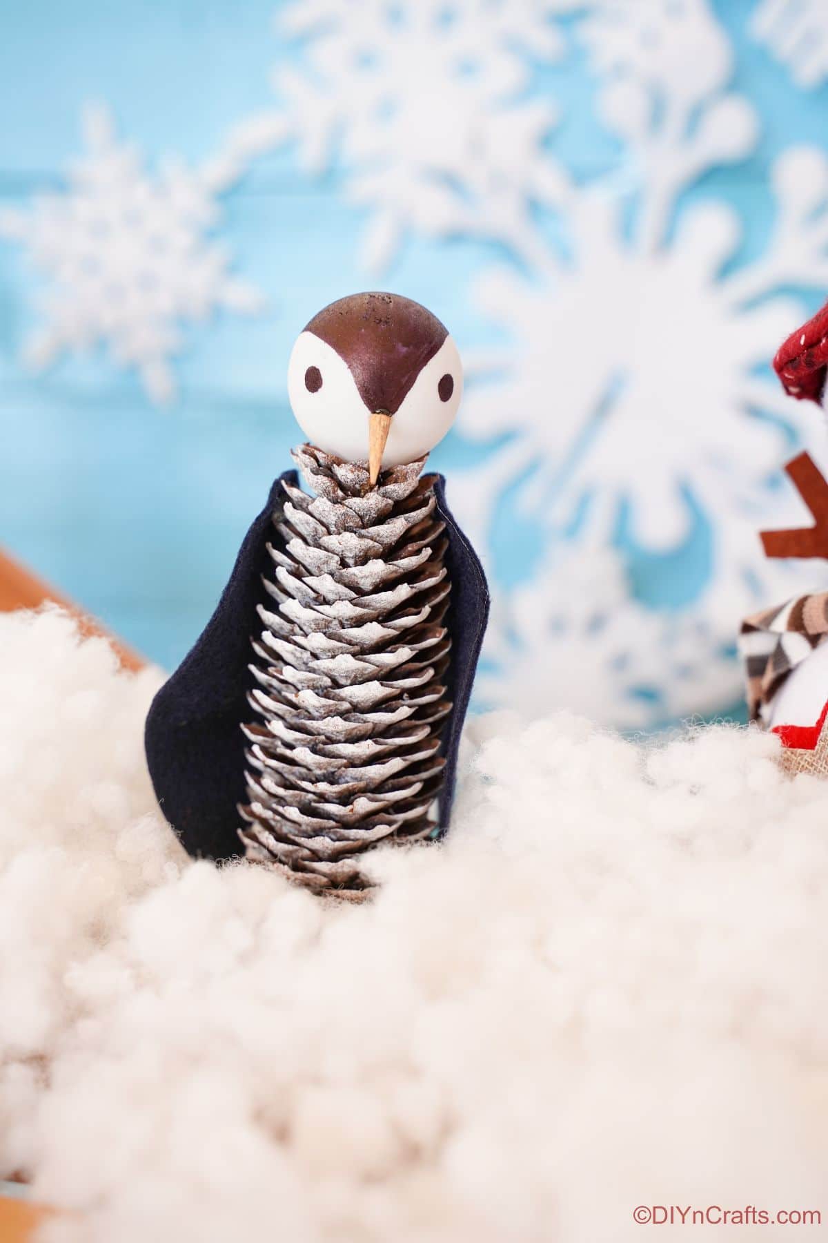 miniature penguin made of pinecones on fake snow
