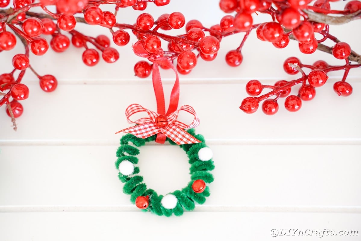 pipe cleaner wreath ornament hanging on white wall